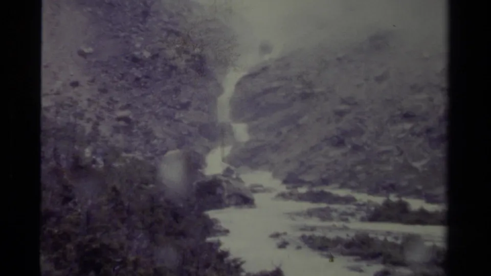 1979 Canadian 8mm frame showing the lower waterfall area, bright water, rocky banks, and evergreen growth.