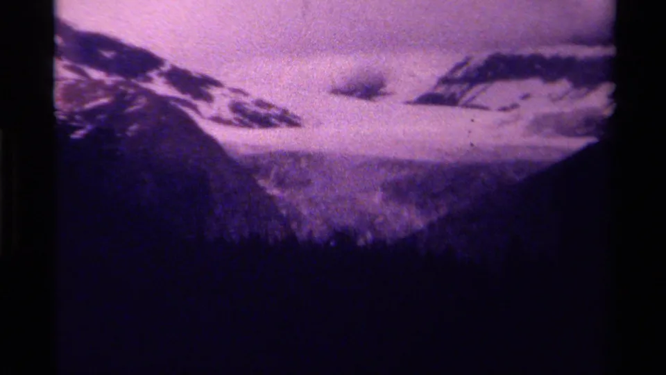 1979 Canadian mountain view showing snow, cloud, and dense treeline in soft, grainy 8mm home-movie footage.