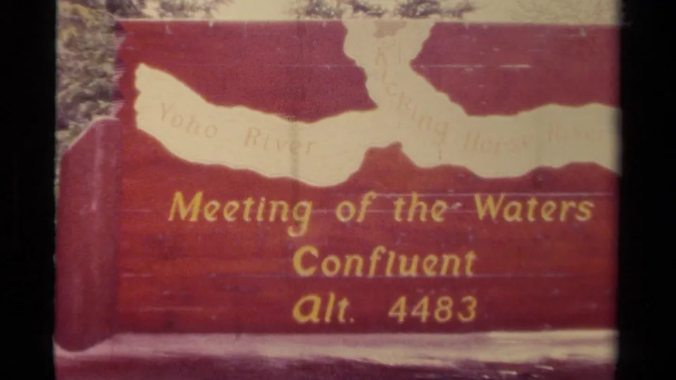 1979 Canada 8mm frame showing a red sign marking Meeting of the Waters Confluent with altitude 4483 and river names partly visible.