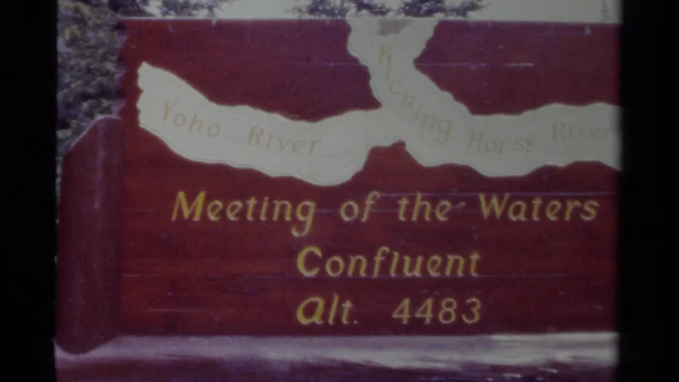1979 Canada 8mm frame showing a red Meeting of the Waters confluence sign with a pale river map and gold lettering.