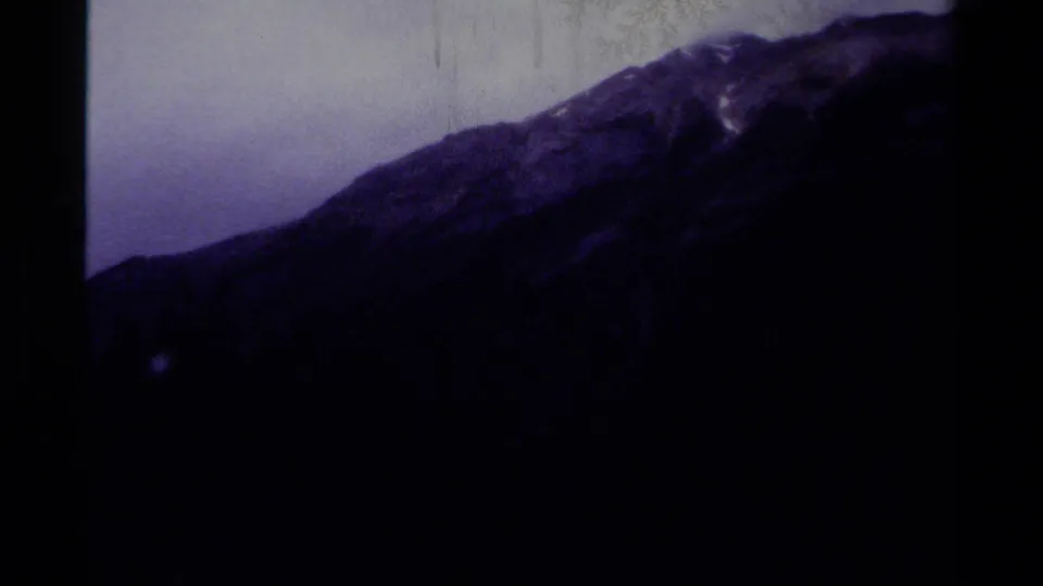 1979 Canada 8mm frame showing a dark, purple-tinted mountain slope after the confluence sign sequence.