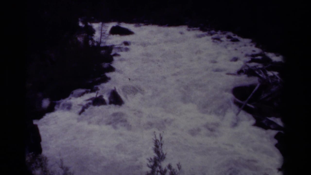 1979 Canadian park home-movie frame showing foaming rapids rushing through a dark rocky channel.
