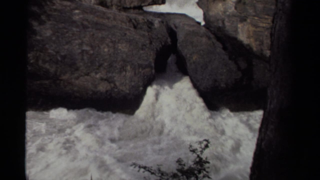 1979 Canadian 8mm frame showing foaming waterfall water rushing through a narrow rocky passage.