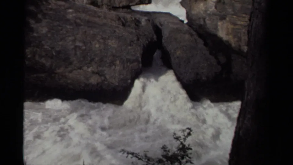 1979 Canadian 8mm frame showing foaming waterfall water rushing through a narrow rocky passage.