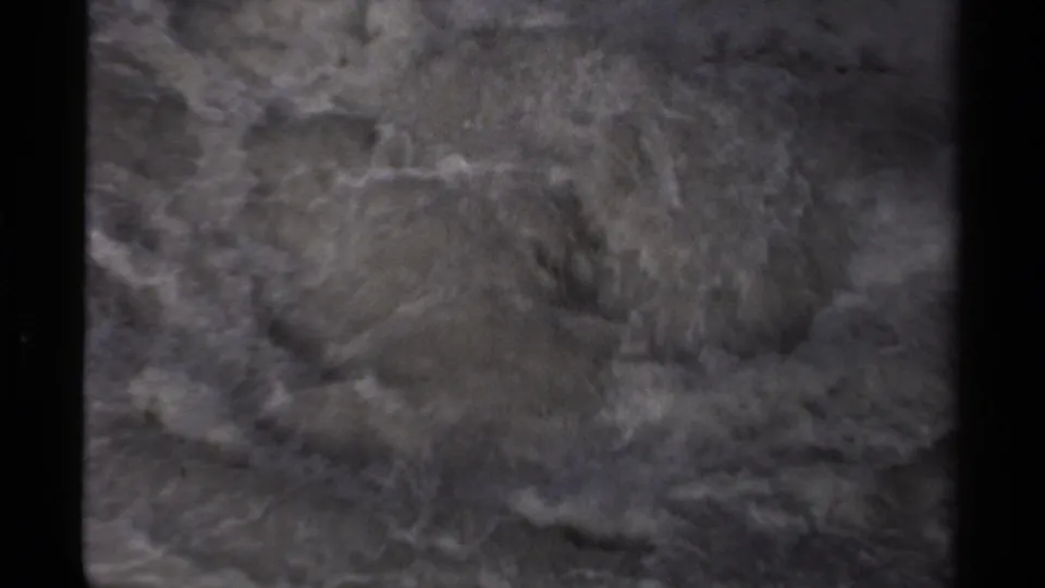 1979 Canada 8mm frame showing churning rapids, foam patterns, and shadowed rock at the top edge.