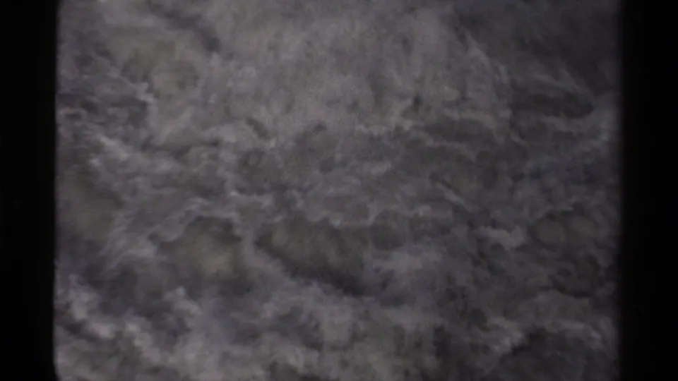 1979 Canadian 8mm frame showing turbulent river water and pale foam moving around dark rocks.