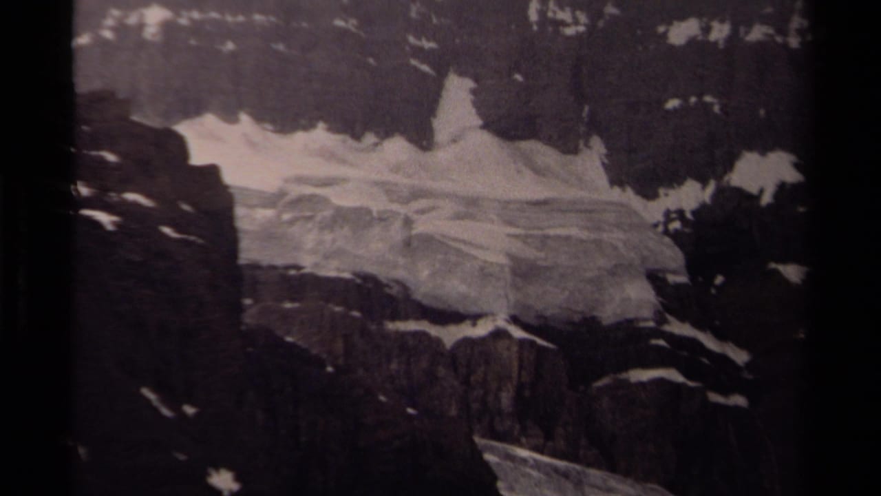 1979 Canadian 8mm frame with glacial ice spread across dark cliffs and snow-streaked alpine rock.