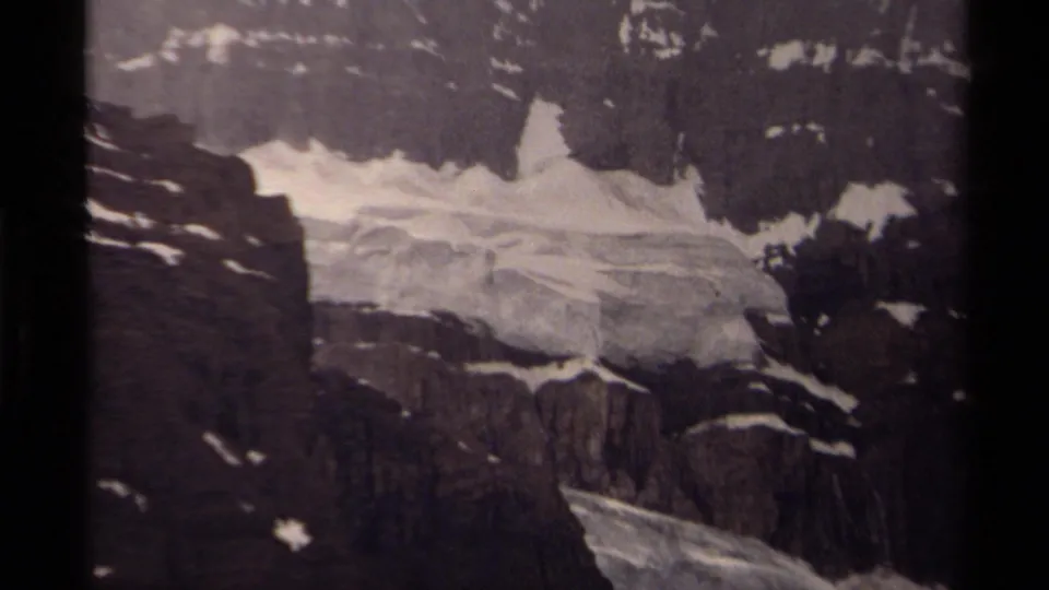 1979 Canadian 8mm frame focusing on fractured glacial ice and snow against rugged rock walls.