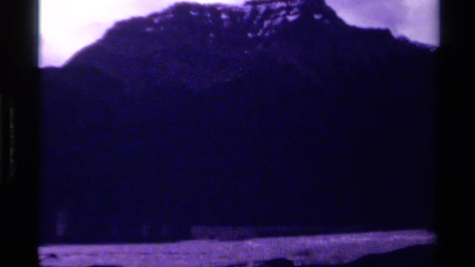 1979 Canada 8mm frame showing a dark mountain silhouette, pale purple sky, and water along the lower edge.
