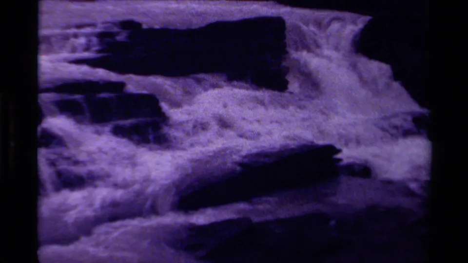 1979 Canadian 8mm frame of a wide waterfall section, with white water, dark rock bands, and visible analog grain.
