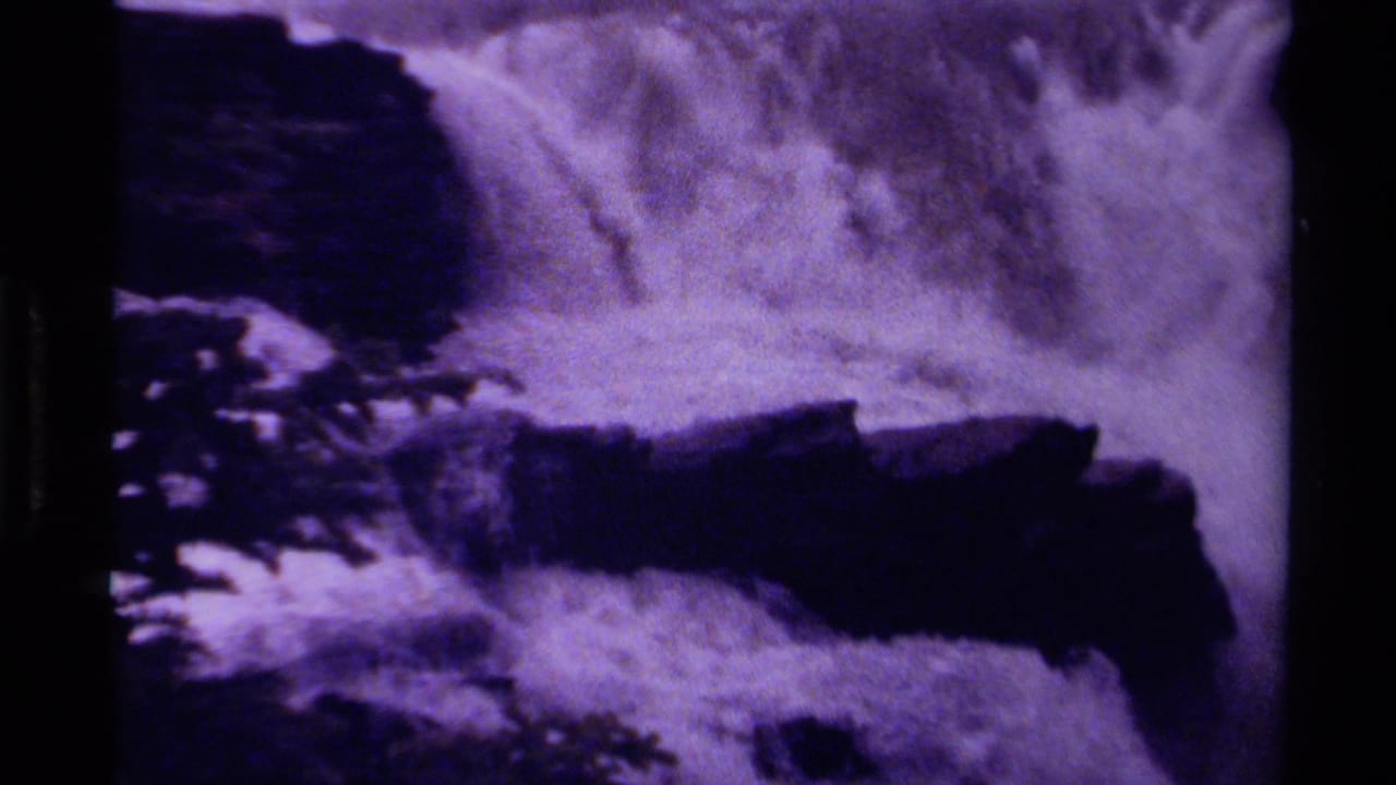 1979 Canada 8mm frame with rushing white water falling over shadowed rock forms and visible scan borders.