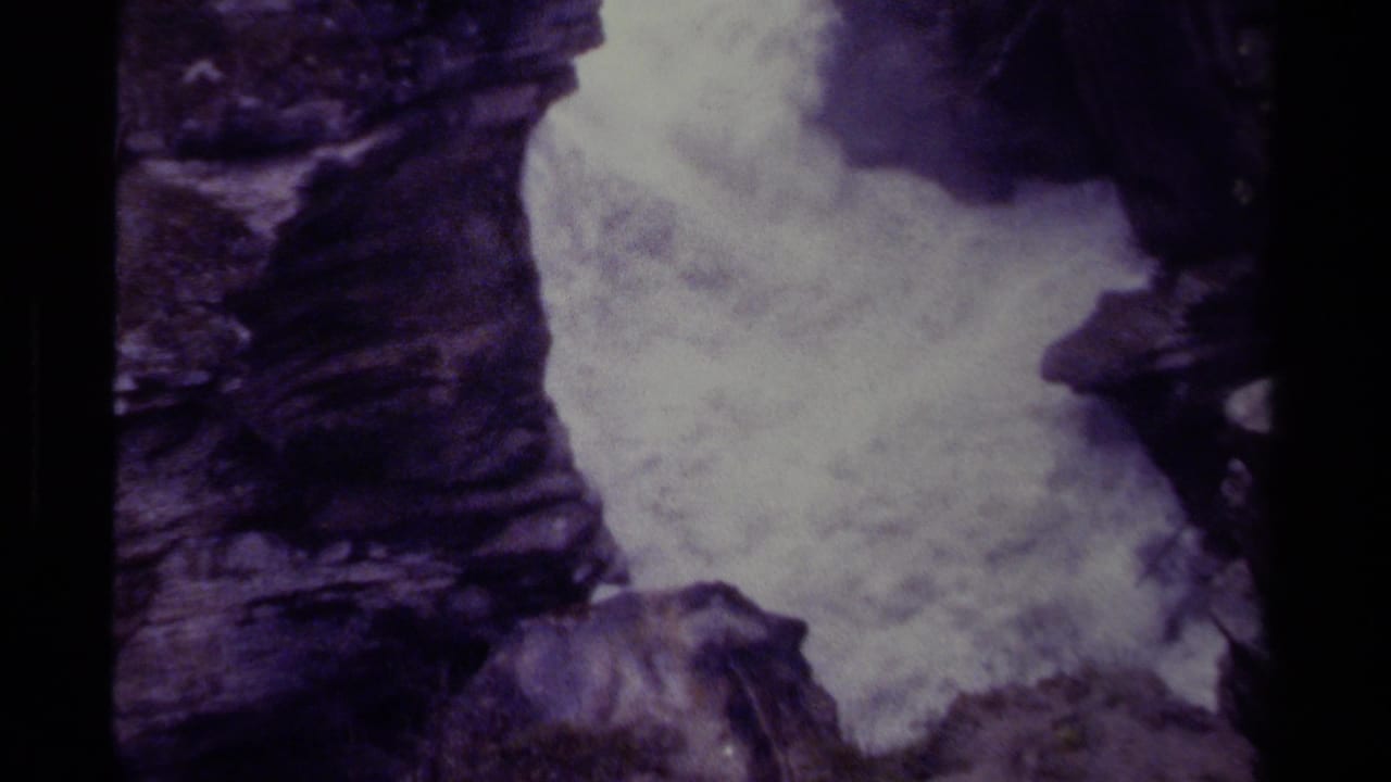 1979 Canadian 8mm frame showing foaming waterfall water framed tightly by dark, rugged gorge rock.