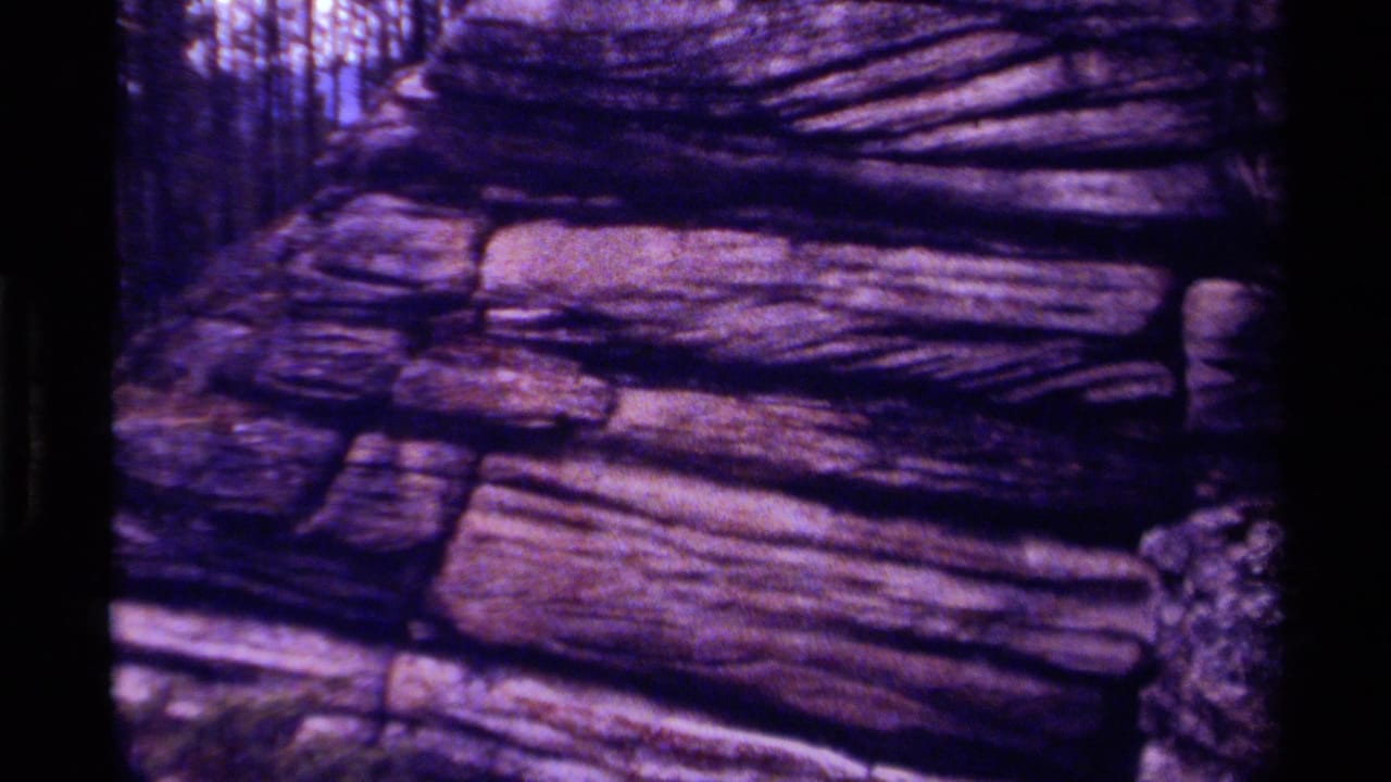 Canadian 8mm frame from 1979 showing striated canyon rock, dark shadows, and visible small-gauge film grain.