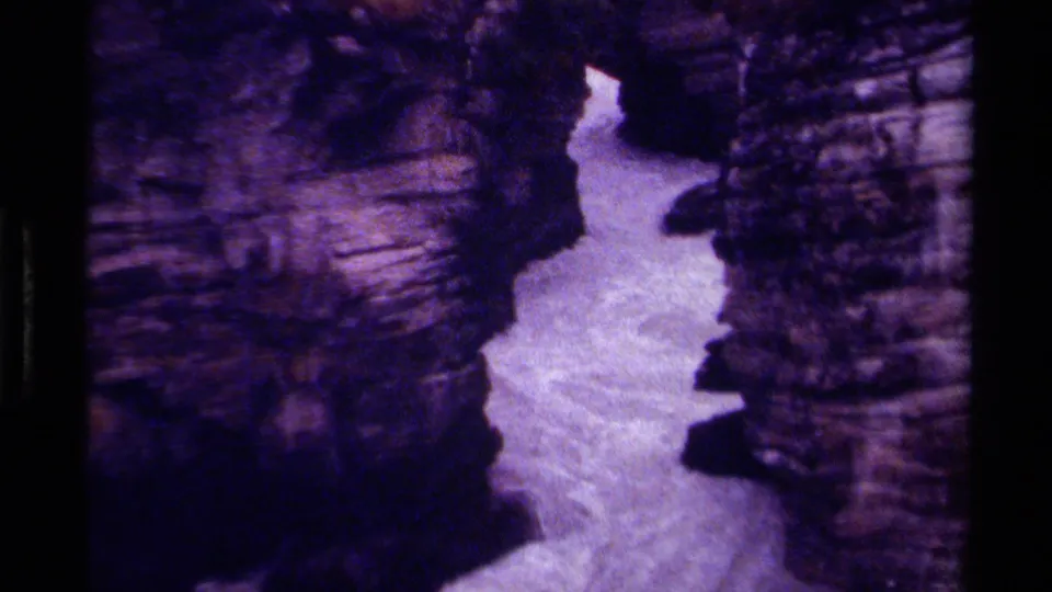 1979 Canada 8mm frame showing pale rushing waterfall water passing through a narrow rocky canyon.