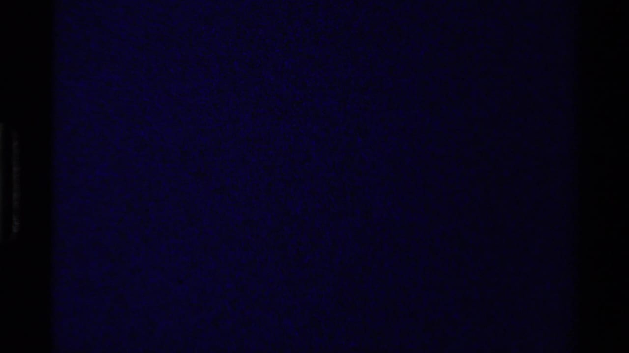 Opening 8mm frame from the 1979 Canada clip, largely dark with a muted blue-purple cast and visible film borders.