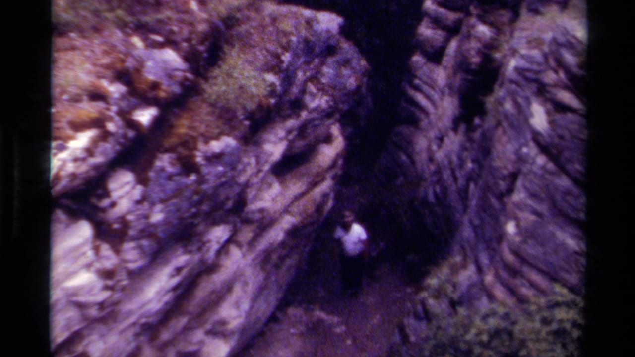 Rocky canyon passage with a man partly visible near the center.