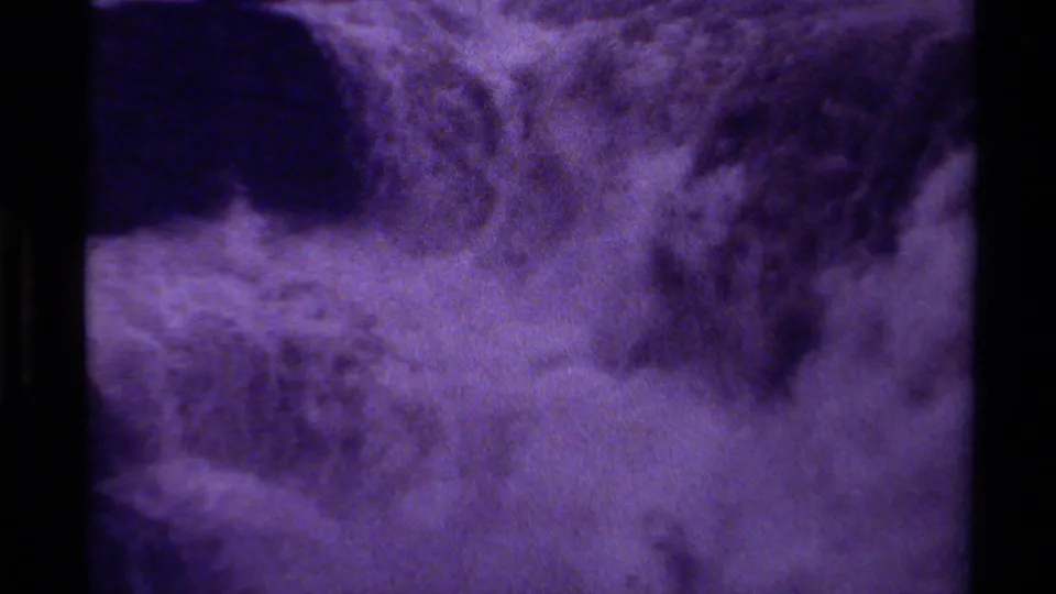 The camera shifts to a close view of turbulent waterfall water, with spray and soft purple-toned 8mm grain.
