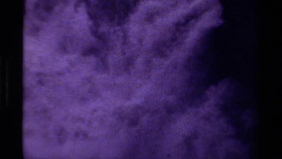 Purple-tinted 8mm frame from Canada, 1979, showing indistinct swirling texture and dark edge shadow.