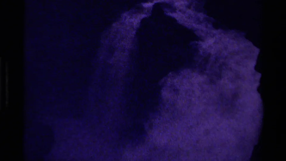 1979 Canadian 8mm frame showing a dark purple field and a lighter rounded abstract form in grainy motion.