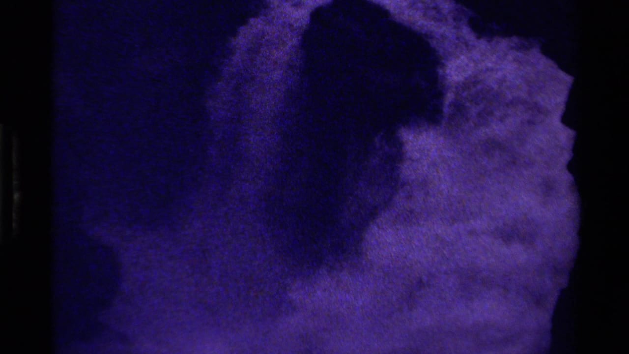 1979 Canada 8mm frame showing a close abstract purple-blue glacier-like surface with dark shadow areas and heavy grain.
