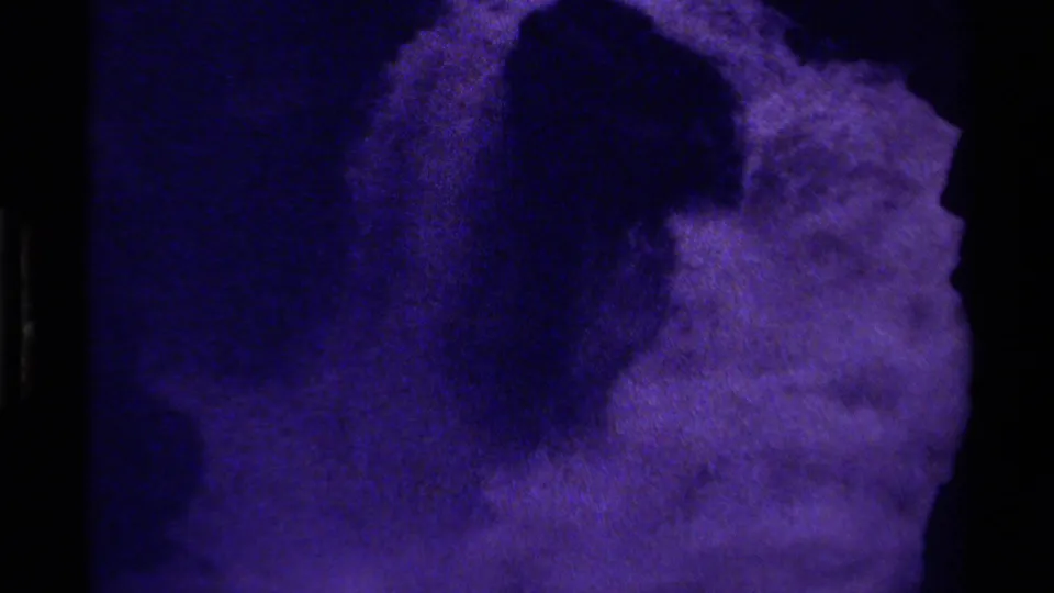 1979 Canada 8mm frame showing a close abstract purple-blue glacier-like surface with dark shadow areas and heavy grain.