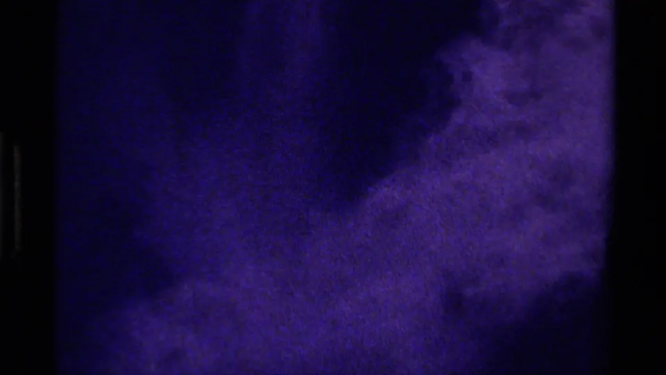 1979 Canada 8mm close-up of a mottled purple-blue glacial surface, with large dark shadow forms and soft grain.
