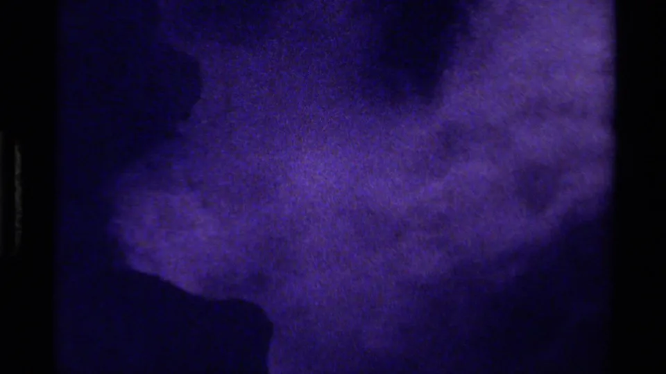 1979 Canada 8mm frame of an abstract icy or rocky surface, tinted blue-purple, with a dark lower notch and coarse grain.