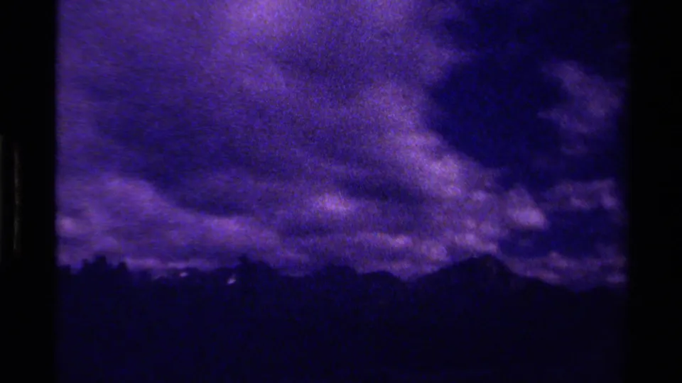 1979 Canadian 8mm view of a dark mountain ridgeline beneath heavy clouds and visible film grain.