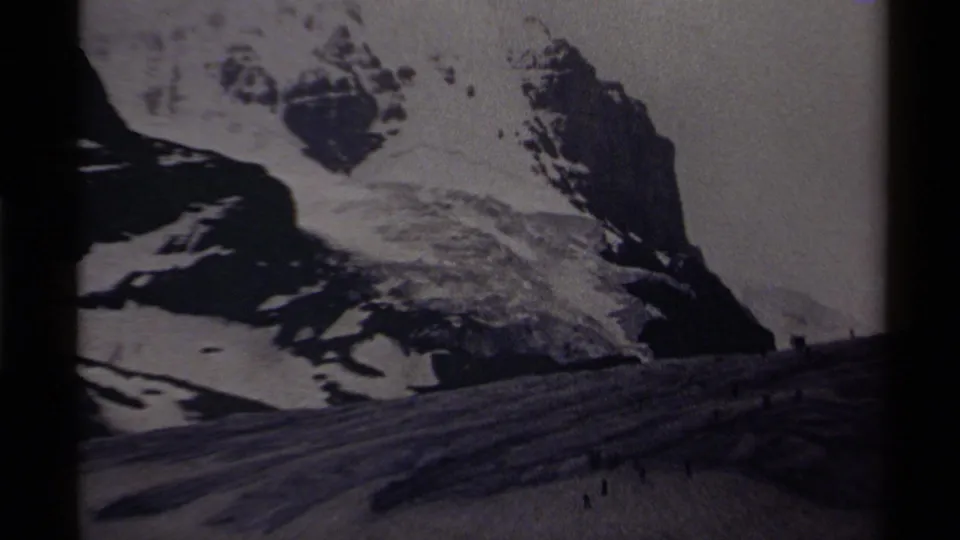 1979 Canada home-movie frame of rugged snowy peaks and a glacier foreground with distant people near the lower frame.