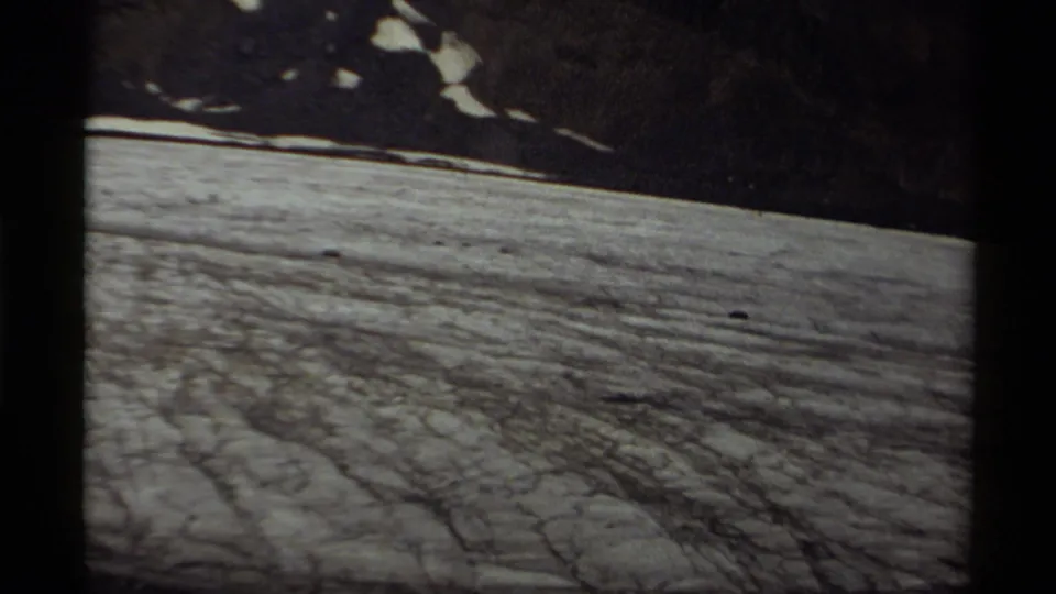 1979 Canada 8mm frame showing a textured snowfield beneath dark, snow-patched mountain slopes.