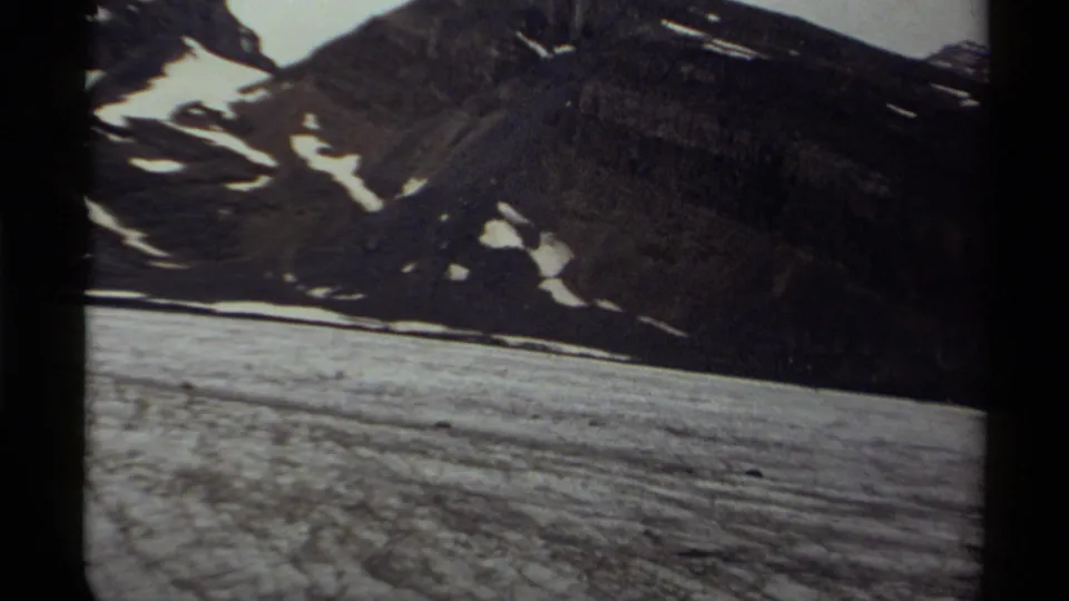 1979 Canada 8mm frame with a slightly tilted snowfield, dark mountain slope, and visible contact-sheet borders.