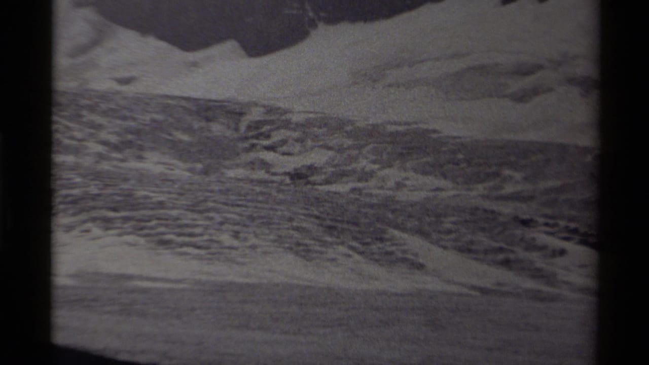 1979 Canadian home-movie frame showing icy, rugged terrain with snow patches and dark 8mm film borders.