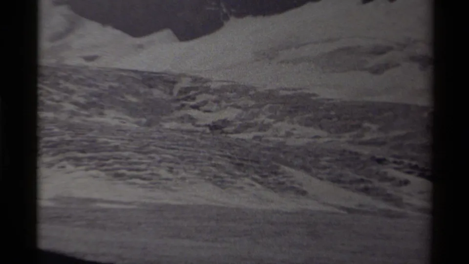 1979 Canadian home-movie frame showing icy, rugged terrain with snow patches and dark 8mm film borders.