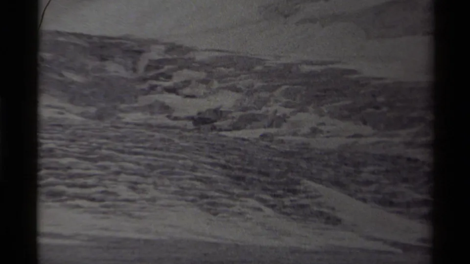 Wide 8mm view of icy Canadian terrain, with layered ridges and snow visible across the distant ground.