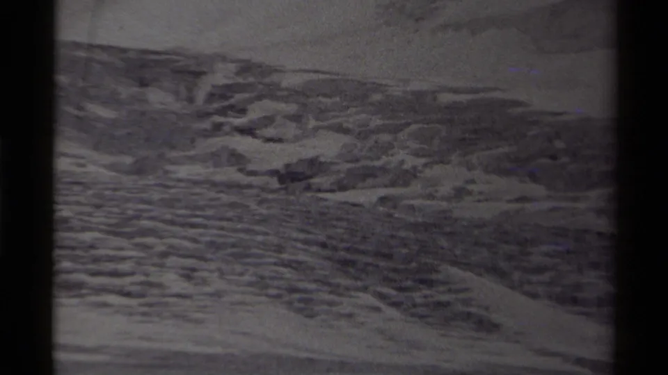 Canadian wilderness frame from 1979 showing snow-streaked terrain and rocky forms within a dark film gate.