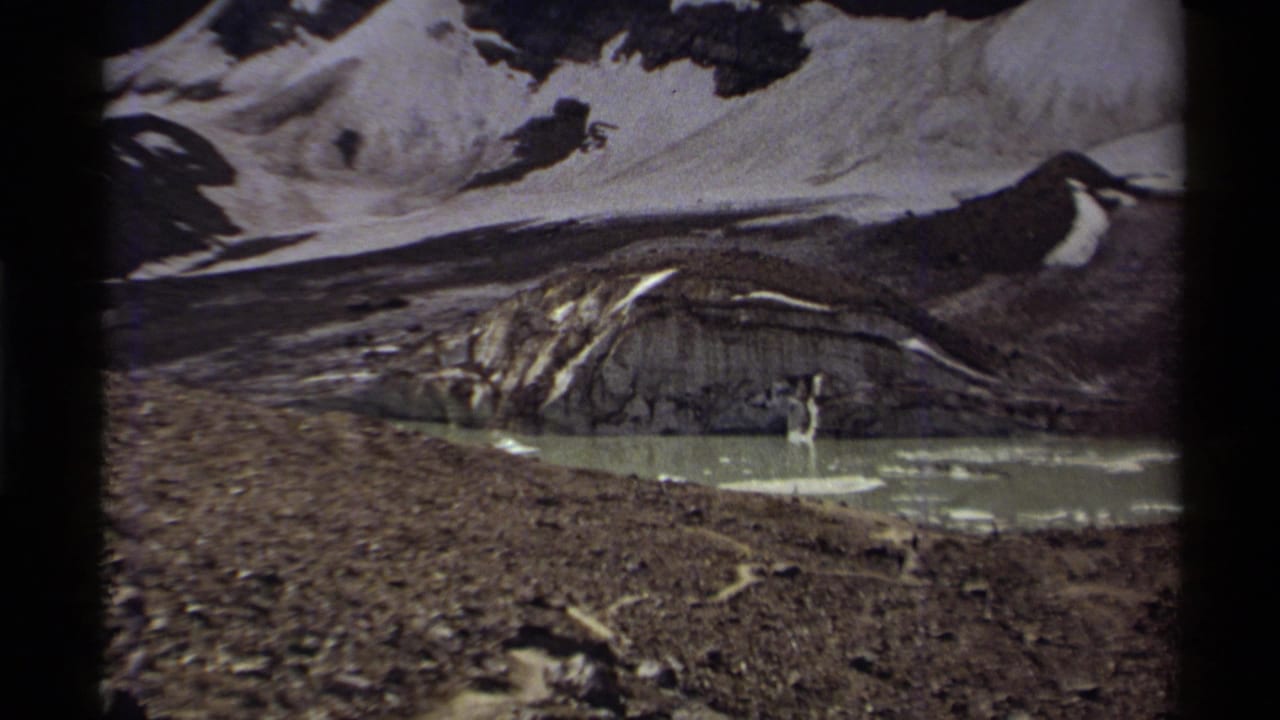 Glacier and exposed rocky slope with pale meltwater in a mountain basin.