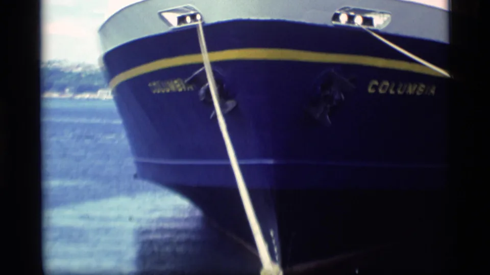 Close 1977 Alaska frame of the Columbia ferry bow, showing the name on the hull and a taut mooring line over calm water.
