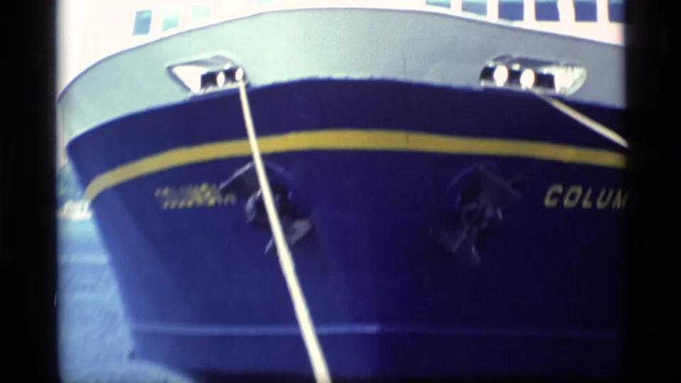 1977 Alaska 8mm frame showing the bow of the blue-and-white passenger ship Columbia secured with dock lines.
