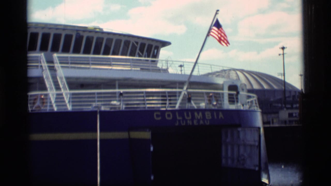 Columbia ferry at dock with an American flag flying above the hull.