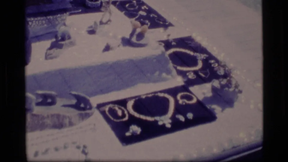 1977 Alaska 8mm frame showing a display case with necklaces, rings, and small jewelry pieces.