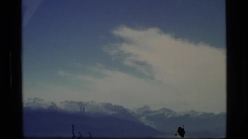 1977 Alaska 8mm view of a distant mountain skyline and a large cloud bank across the upper frame.