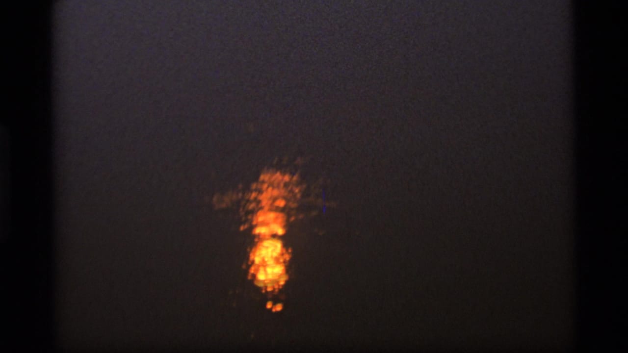 Bright orange sun reflection shimmering on dark water.
