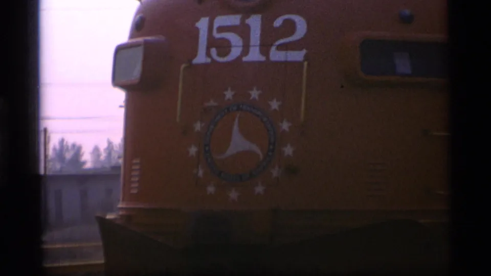 Close 1977 Alaska rail footage shows the yellow locomotive front marked 1512 with a circular star emblem and dark cab windows.