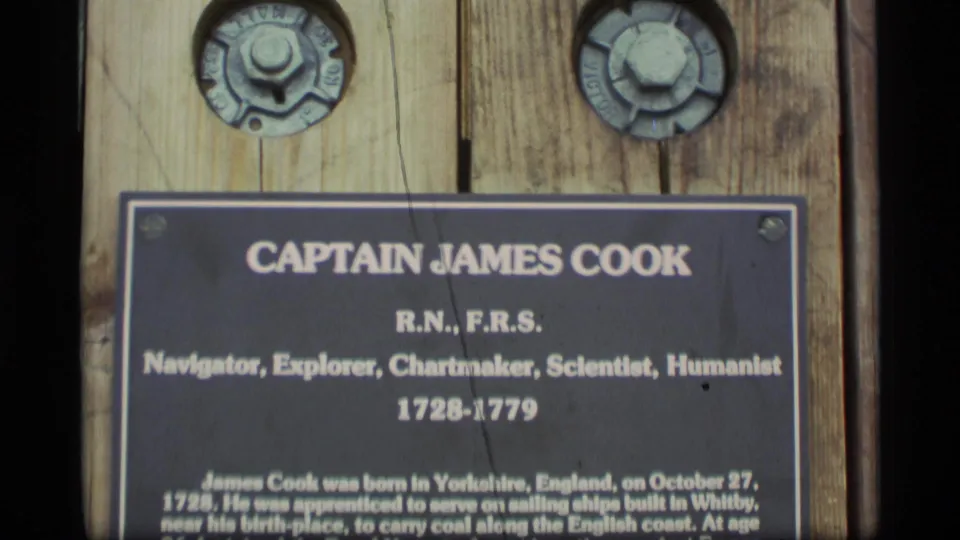 1977 Alaska frame showing the black Captain James Cook plaque, its title text, dates 1728-1779, and weathered wooden support.