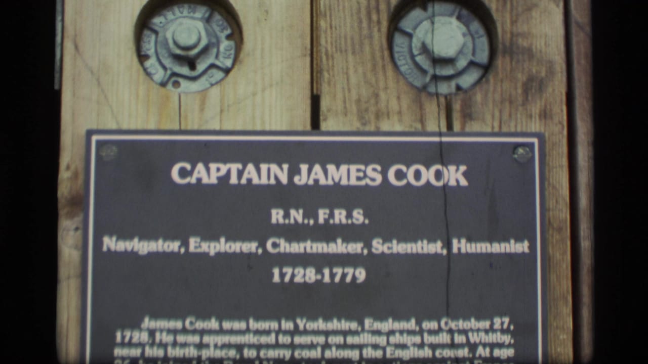 Close view of a Captain James Cook commemorative plaque mounted on wood.