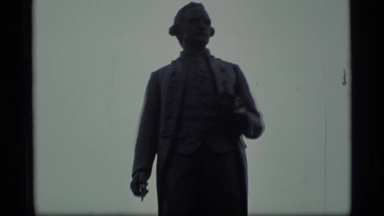 Close 8mm view of a silhouetted public statue, likely in Alaska based on clip metadata.