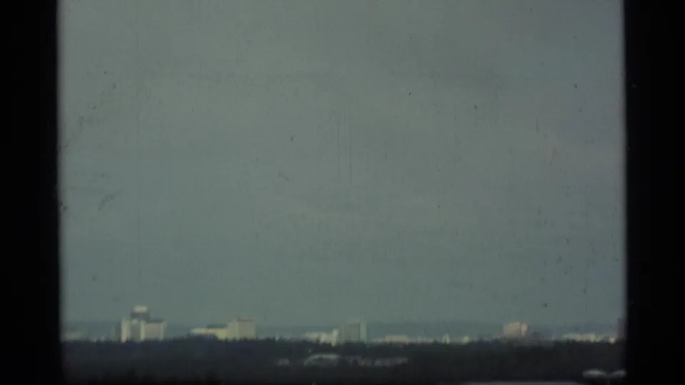 Distant skyline through haze in Alaska 1977 home-movie footage, framed from an airport or nearby travel viewpoint.