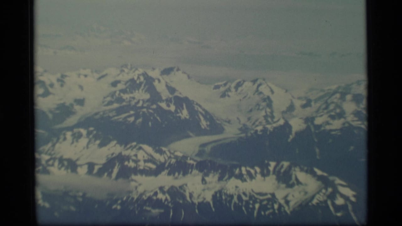 Distant snowy mountain range with glaciers and dark ridgelines.