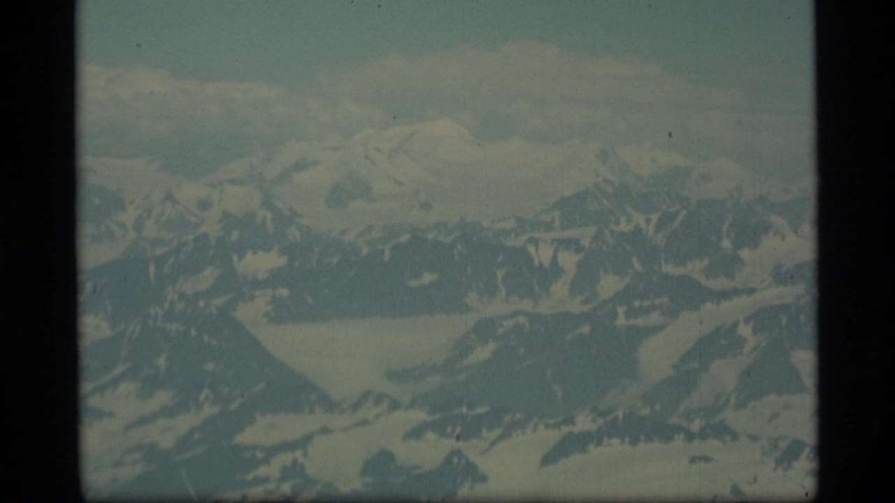 Snowy mountain peaks and glacier valleys viewed from an aircraft.