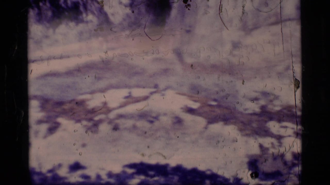 1977 Alaska 8mm frame showing a soft, purple-tinted snowy slope or ice field with dark borders and visible film wear.